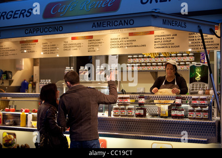 Paio di decidere su una bevanda calda da venditore ambulante in un freddo tardo autunno sera . shopping per valore. Edimburgo in Scozia. Foto Stock