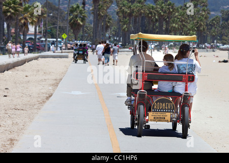 Famiglia in un Deuce Coupe peddle bicicletta sul lungomare di Santa Barbara Beach California Foto Stock