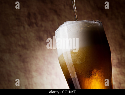 La birra in vetro su una antica pietra Foto Stock