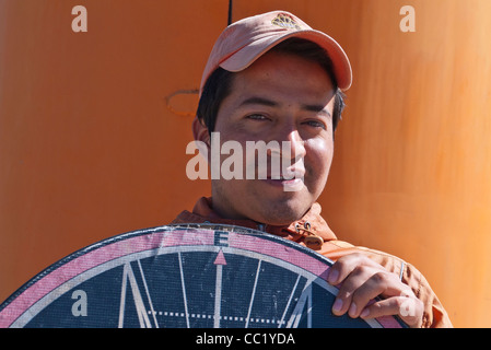 Un giovane adulto insegna a turisti e altri visitatori circa l'equatore presso il monumento per l'equatore, a nord di Quito, Ecuador. Foto Stock