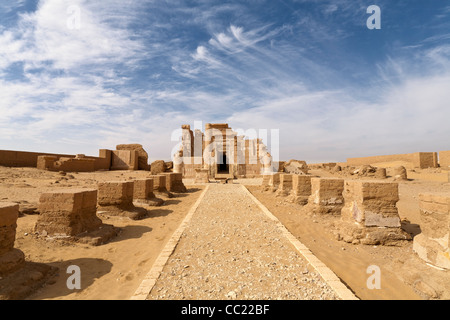 Luce Wispy nuvole nel cielo blu sopra il tempio romano di Deir el-Hagar, Dakhla Oasis, deserto occidentale d'Egitto Foto Stock