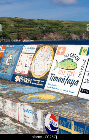 Una visita di yachtsman mano-dipinge una nave's calling card sulla marina di pareti a Horta, isola di Faial nelle Azzorre Foto Stock