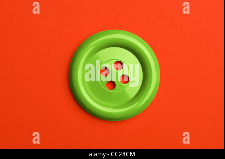 Un pulsante verde su uno sfondo rosso Foto Stock