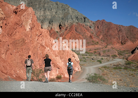 I turisti a piedi su sentiero escursionistico attorno al villaggio Purmamarca, provincia di Jujuy, Argentina Foto Stock