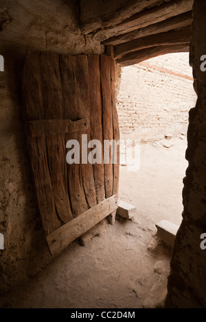Pesante porta di legno nello storico villaggio di El-Qasr a Dakhla Oasis. Western Desert, Egitto Foto Stock