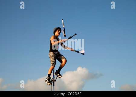 Street performer sul monociclo giocoleria con torcia a Mallory Square a Key West, Florida Keys, Florida, Stati Uniti d'America Foto Stock