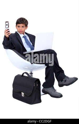 Ragazzo giovane vestito come un burbero uomo d affari Foto Stock