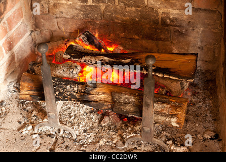 Caminetto in mattoni con tronchi di legno la masterizzazione Foto Stock