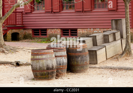 Set di vecchie botti di rovere in strada al di fuori di un vecchio dipinto di rosso house Foto Stock