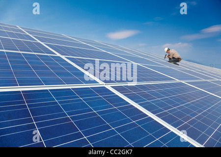 Chiudere pannello solare e il lavoratore professionale di installare pannelli solari fotovoltaici Foto Stock