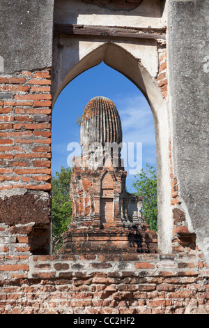 Le antiche rovine di Wat Phra Si Rattana Mahathat, Lopburi, Thailandia.un lato prang come si vede da una finestra nel tempio principale Foto Stock