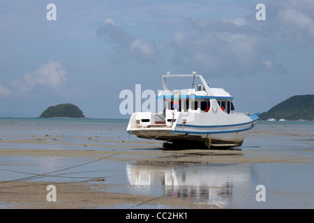 Una completamente attrezzati motorizzato barca da pesca appoggia sulla sabbia durante la bassa marea in Chalong Bay, Isola di Phuket, Tailandia. Foto Stock