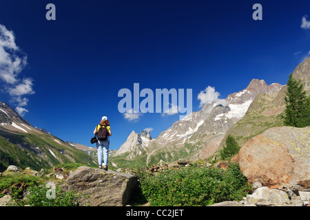 Giovane donna si erge su una roccia nelle Alpi Italiane Foto Stock