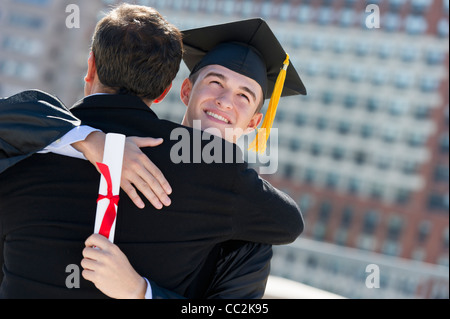 Stati Uniti d'America, New Jersey, Jersey City, Padre con teenage sun (16-17) alla cerimonia di consegna dei diplomi Foto Stock