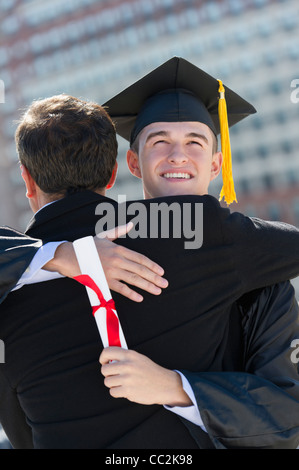 Stati Uniti d'America, New Jersey, Jersey City, Padre con teenage sun (16-17) alla cerimonia di consegna dei diplomi Foto Stock