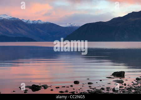 Mattina twilight oltre il lago Wanaka e le vette innevate delle Alpi meridionali, Wanaka, Otago, Nuova Zelanda Foto Stock