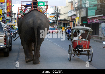 Saamlaw (tre ruote pedicab) condividendo le strade con elefante taxi. Surin, Surin, Thailandia Foto Stock