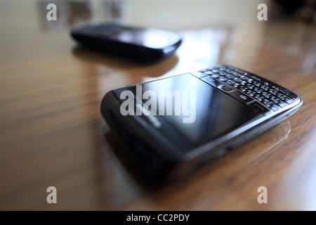 Due telefoni cellulari su una scrivania superficie simile Foto Stock