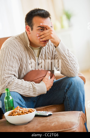 Stati Uniti d'America, New Jersey, Jersey City, uomo seduto sulla poltrona a guardare lo sport in TV Foto Stock