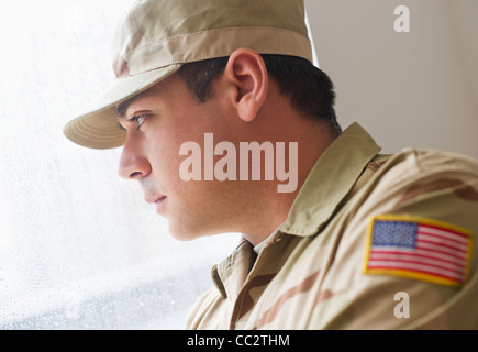 Stati Uniti d'America, New Jersey, Jersey City, uomo che indossa uniforme militare guardando attraverso la finestra Foto Stock