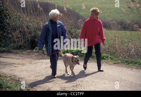 Due donne mature passeggiate in campagna con il cane Foto Stock