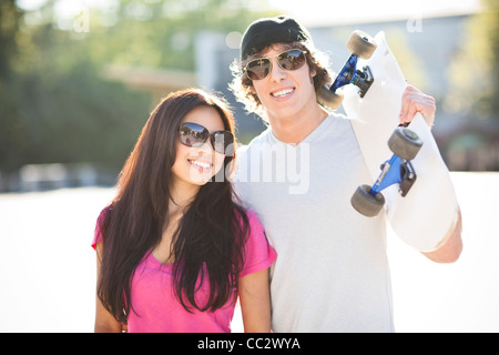 Stati Uniti d'America, Washington, Seattle, giovani multi-razziale matura in posa con lo skateboard Foto Stock