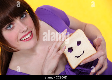 Donna con una faccina scolpita in pane Foto Stock