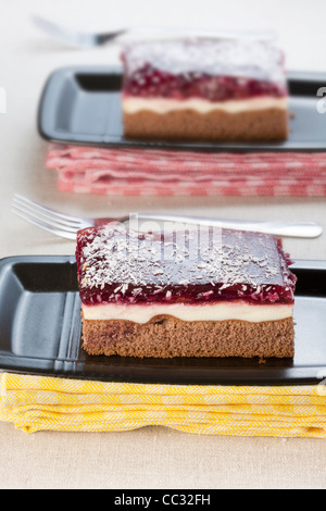 Due fette di torta di cioccolato con panna e topping di frutta Foto Stock