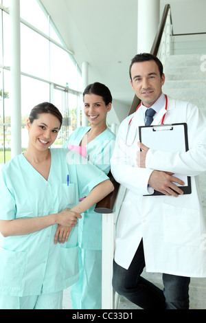 Medico e due infermieri in piedi su una scala in un ospedale Foto Stock