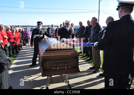 Militari gli onori funebri e la piegatura dell'alfiere nazionale a seguito di un servizio funebre. Foto Stock