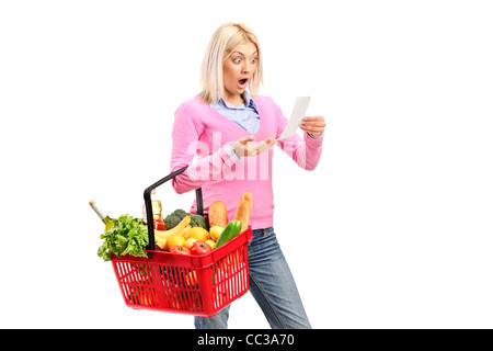 Una donna sorpresa guardando la ricevuta del negozio e trattenimento di un carrello Foto Stock