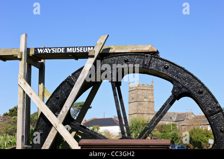 Zennor Cornwall Inghilterra England Regno Unito. Trewey mulino ad acqua di lavoro ruota fuori strada con il Museo villaggio chiesa di St Senara oltre Foto Stock