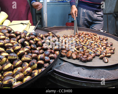 L'uomo la vendita calda castagne arrosto in strada di roma italia Foto Stock