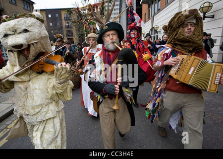 Artisti e musicisti accompagnano un annuale tradizionale teatro libero di celebrare un 'wassail' Herald per il nuovo anno Foto Stock