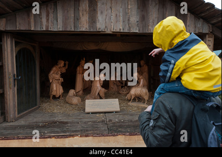 Scena della Natività. Padre e figlio ammirare scolpito a mano figure in legno.Erfurt Mercatino di Natale. Piazza del Duomo.Turingia Germania Foto Stock