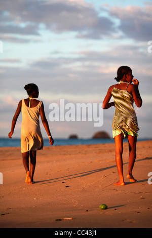 Due giovani donne malgascio a piedi presso la spiaggia di Ampangorinana, Nosy Komba, nord-occidentale del Madagascar, Africa, al tramonto. Foto Stock