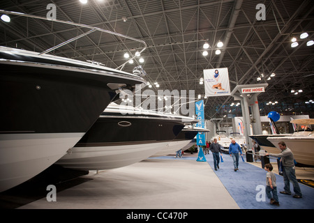 I potenziali acquirenti e persone solo navigando controllare le barche a motore al Progressive Insurance New York Boat Show Foto Stock