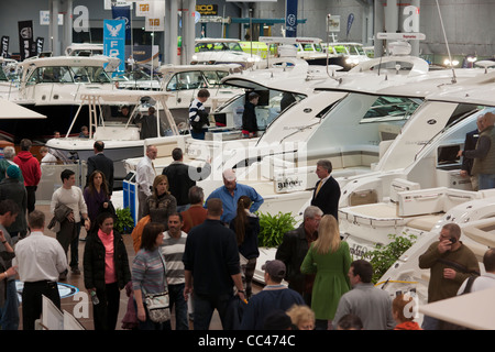 I potenziali acquirenti e persone solo navigando controllare le barche a motore al Progressive Insurance New York Boat Show Foto Stock