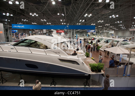 I potenziali acquirenti e persone solo navigando controllare le barche a motore al Progressive Insurance New York Boat Show Foto Stock