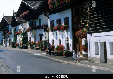 Austria, austriaca, Tirol, Mutters, la strada principale rivestita con case tradizionali la visualizzazione di fioriere in piena fioritura. Foto Stock