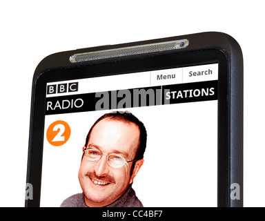 Ascolto di radio della BBC 2's Steve Wright nel pomeriggio in streaming su uno smartphone HTC Foto Stock