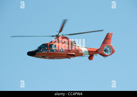 Guardia Costiera degli Stati Uniti elicottero in volo e isolate su un cielo blu chiaro Foto Stock