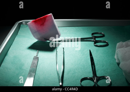 Macchiato di sangue tampone sul vassoio chirurgico Foto Stock