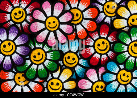 Ferro da ricamo sulle patch di variopinte Smiley face fiori su sfondo nero Foto Stock