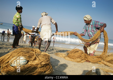 Fotografia di Roy Riley pescatori scacciando le loro reti sulla spiaggia a Kovalam in Kerala, India Foto Stock