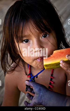 Embera Puru bambino indiano che mangia il melone d'acqua nel villaggio accanto a Rio Pequeni, provincia di Colon/Panama, Repubblica di Panama, America Centrale. Foto Stock