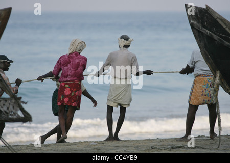 Fotografia di Roy Riley pescatori scacciando le loro reti sulla spiaggia a Kovalam in Kerala, India Foto Stock