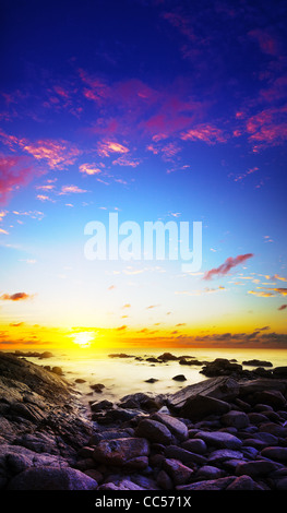 Vista di un tramonto spettacolare sul mare. Una lunga esposizione shot. Composizione verticale. Foto Stock