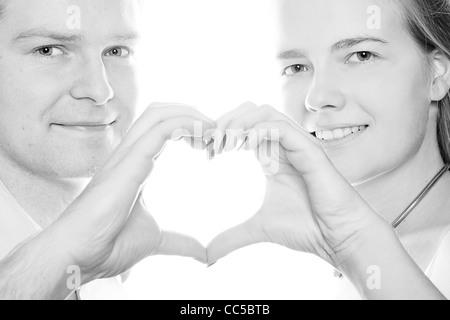 Coppia felice e forma di cuore formata da mani Foto Stock