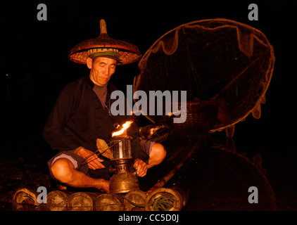 Cormorano illuminazione pescatore la sua lampada in mattina presto le tenebre sul fiume Li Yangshuo Repubblica Popolare Cinese Foto Stock